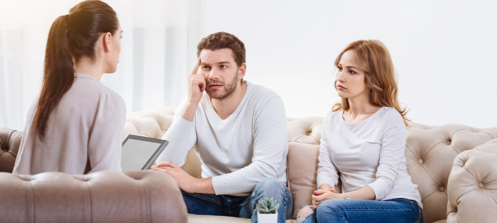 Sad unhappy couple listening to the psychologist